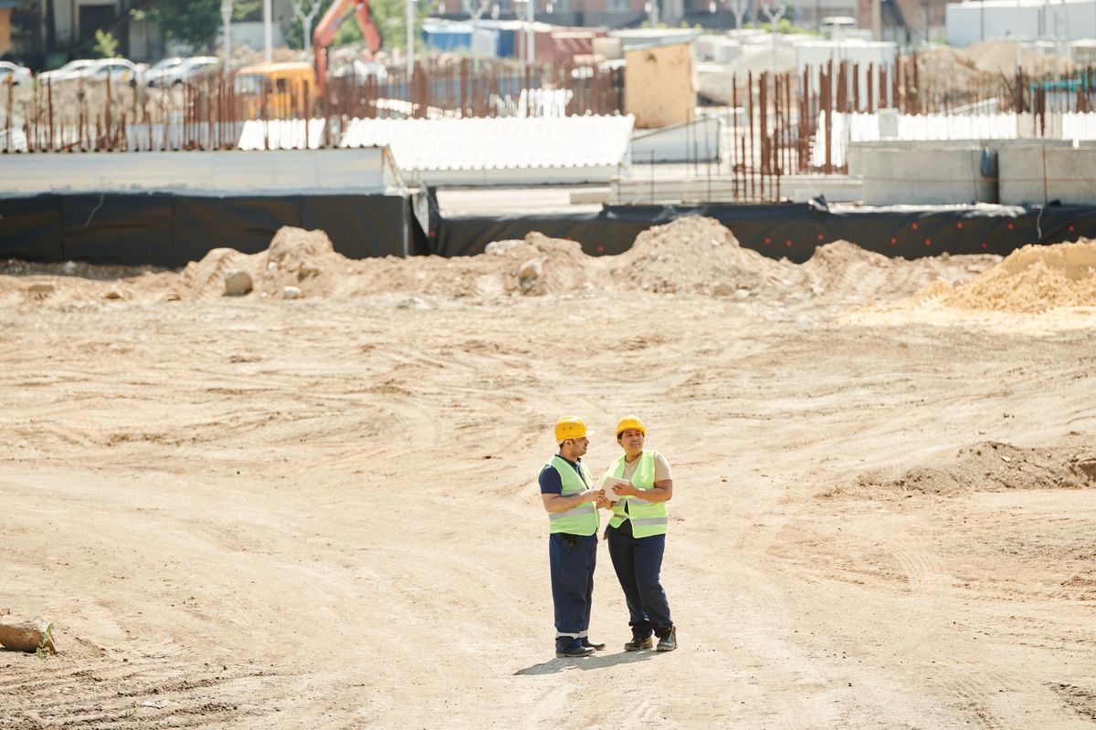 Two construction workers reviewing a site under development