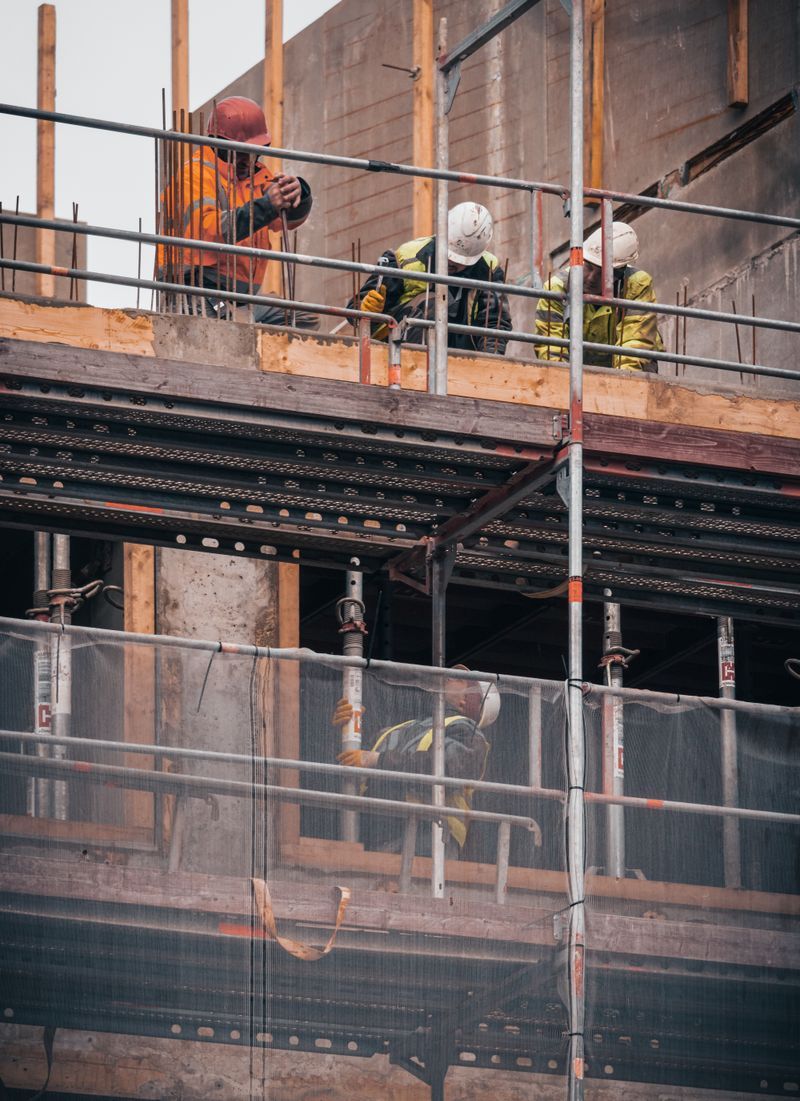 Workers coordinating structural steel installation on a commercial project