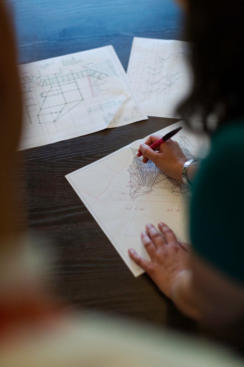 A team member marking up a construction drawing by hand